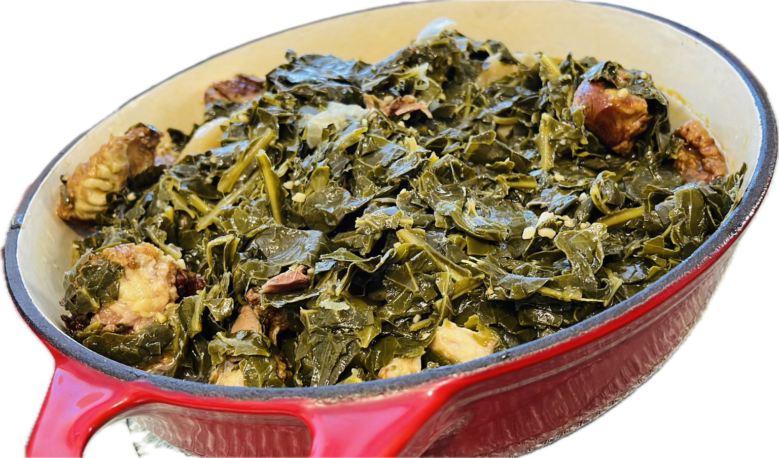 A cast-iron pot of collard greens with smoked ham hock